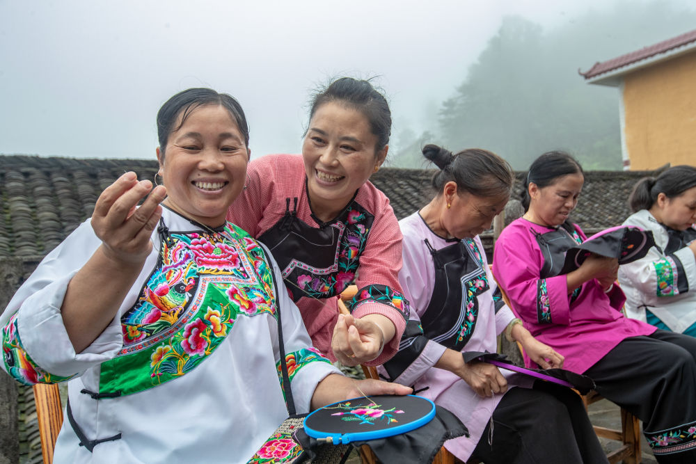 在湖南省湘西土家族苗族自治州花垣县十八洞村,村民在讨论苗绣制作(2020年7月16日摄)。