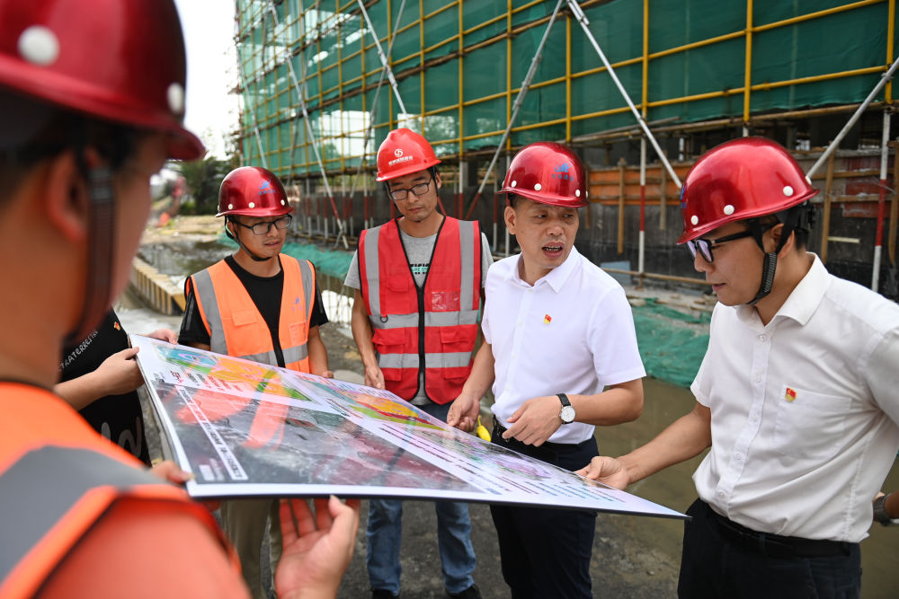 在浙江省宁波市奉化区萧王庙街道滕头村,二十大代表、滕头村党委书记、村委会主任傅平均(右二)在村党群服务中心大楼建设工地察看施工进展(2022年9月16日摄)。